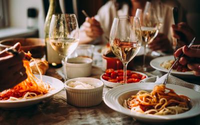 Friends having a pasta dinner at home of at a restaurant.