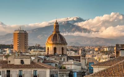 Catania cityscape with the view of Etna volcano at sunset in Sicily